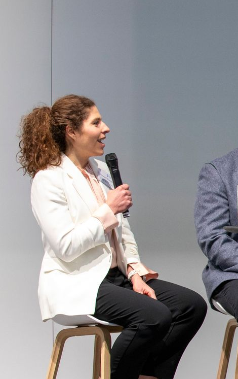 Elisabeth Brandau als Keynote-Speakerin auf der Bühne mit Mikrofon